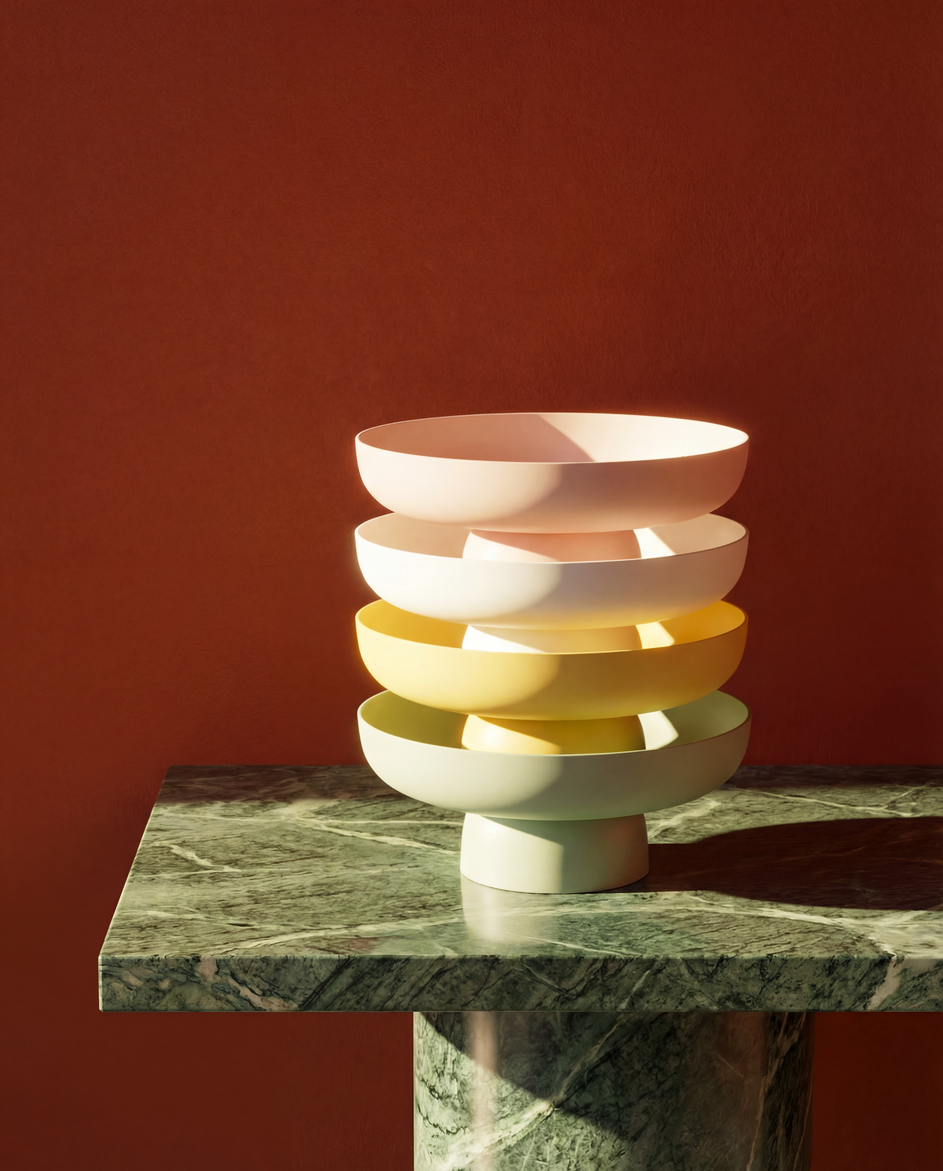 Runda Bowls in Sage, Citron, Chalk and Blush stacked on green marble, showing the sculptural matte bowl collection by Maxim Vogel.